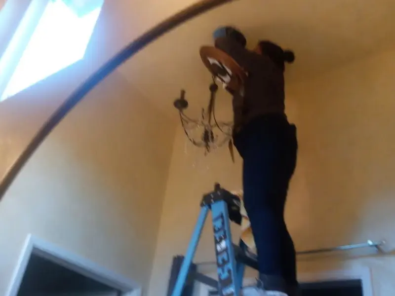 Electrician installing a chandelier in a Fallston residence